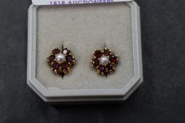A pair of garnet and seed pearl cluster stud earrings in yellow metal mounts stamped 9ct