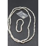 A long string of baroque pearls with matching bracelet and drop earrings