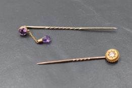 A diamond set stick pin, approx 0.05ct in a yellow metal mount and another similar having amethyst