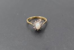 An opal and diamond cluster ring in a claw set mount on an 18ct gold loop, size P & approx 2.6g