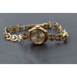 A lady's 9ct gold wrist watch having baton & Arabic numeral dial to small circular face on a 9ct