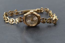 A lady's 9ct gold wrist watch having baton & Arabic numeral dial to small circular face on a 9ct