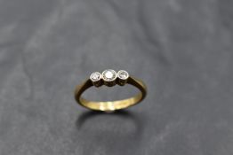 An 18ct gold platinum set three stone diamond ring, the central brilliant cut stone measuring 0.