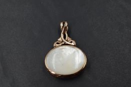 A large fob style pendant having mother of pearl and lapiz lazuli style panels in a 9ct rose gold