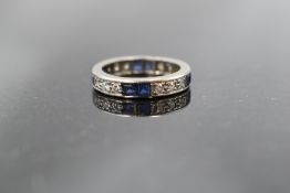 A full eternity ring having baguette cut sapphires and brilliant cut diamonds in a white gold