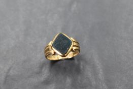 An 18ct gold signet ring having a blood stone panel in a collared mount to moulded shoulders, size P