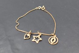 A yellow metal bracelet, having fine box links suspending three charms, all marked 10k, 18cm, 2.