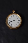 A small yellow metal top wound pocket watch stamped 18K having Roman numeral dial in extensively