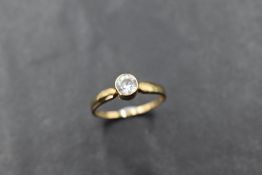 A cubic zirconia solitaire in a collared mount on a 9ct gold loop, size O & approx 1.4g