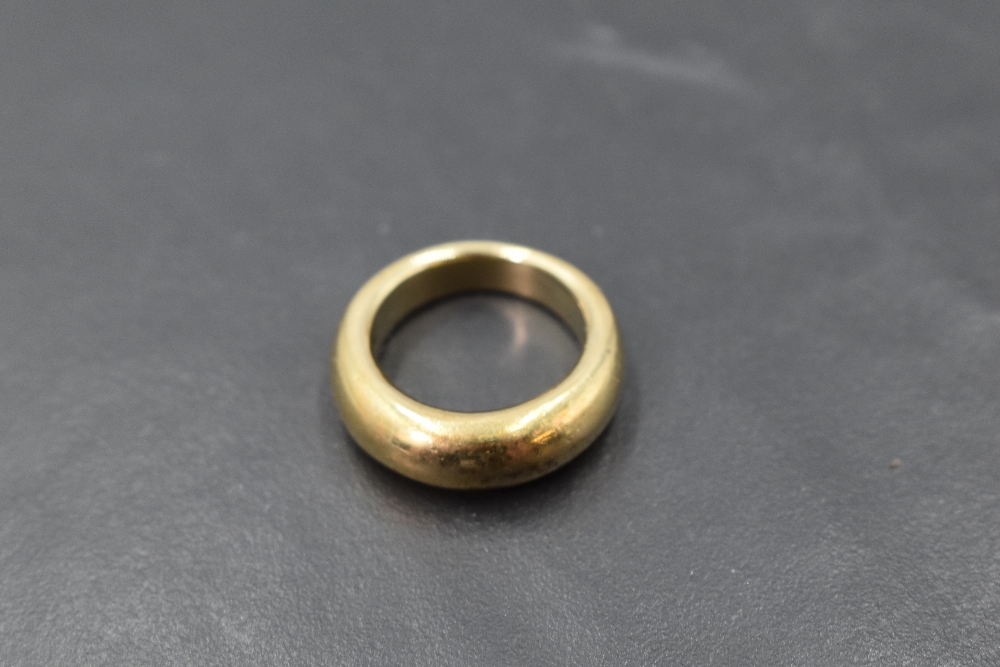 A yellow metal plain moulded band ring, marks worn, size K & approx 10.9g