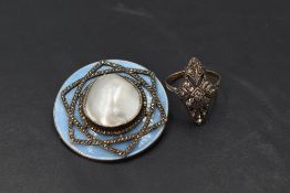A circular brooch having central mother of pearl panel with star shaped marcasite decoration on a