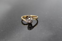A spinel solitaire ring having cross over shoulders on a yellow metal loop stamped 18ct, size L &