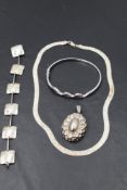 Four pieces of silver jewellery including a hinged bangle, locket, bracelet and necklace
