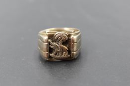 A yellow metal signet ring having elephant and palm tree decoration, tests as gold, size T and