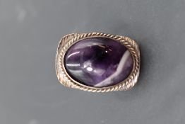 An oversized Blue John ring having an oval stone in a collared mount on stylised white metal loop,