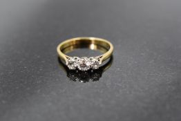 A diamond trilogy ring, total approx 0.25ct in a claw set mount on a yellow metal loop stamped