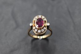 A ruby and diamond open cluster ring in an open collared mount with diamond set shoulders and yellow
