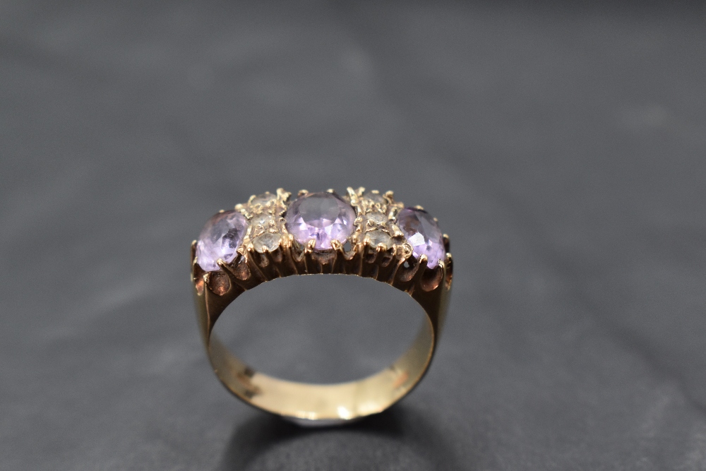 An amethyst trio ring interspersed by six cubic zirconia in a claw set panel mount on a 9ct gold - Image 2 of 3