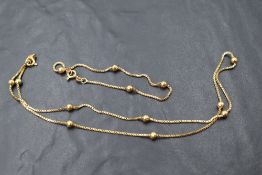 An Italian 10k necklace and bracelet set, having box links with spherical bead ornaments, marked