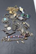 A treen box containing a selection of vintage white metal jewellery including enamelled buckle,