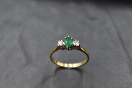 An emerald and diamond trio ring, approx 0.2ct & 0.06ct x 2 in a claw set basket mount on an 18ct