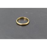 A yellow metal wedding band stamped 18K bearing inscription Proctor's Lucky to the inside, size