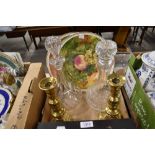 Two vintage decanters, two plates having fruit designs and a pair of brass candlesticks.