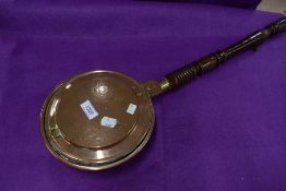 A small sized copper and brass bed warming pan with turned handle