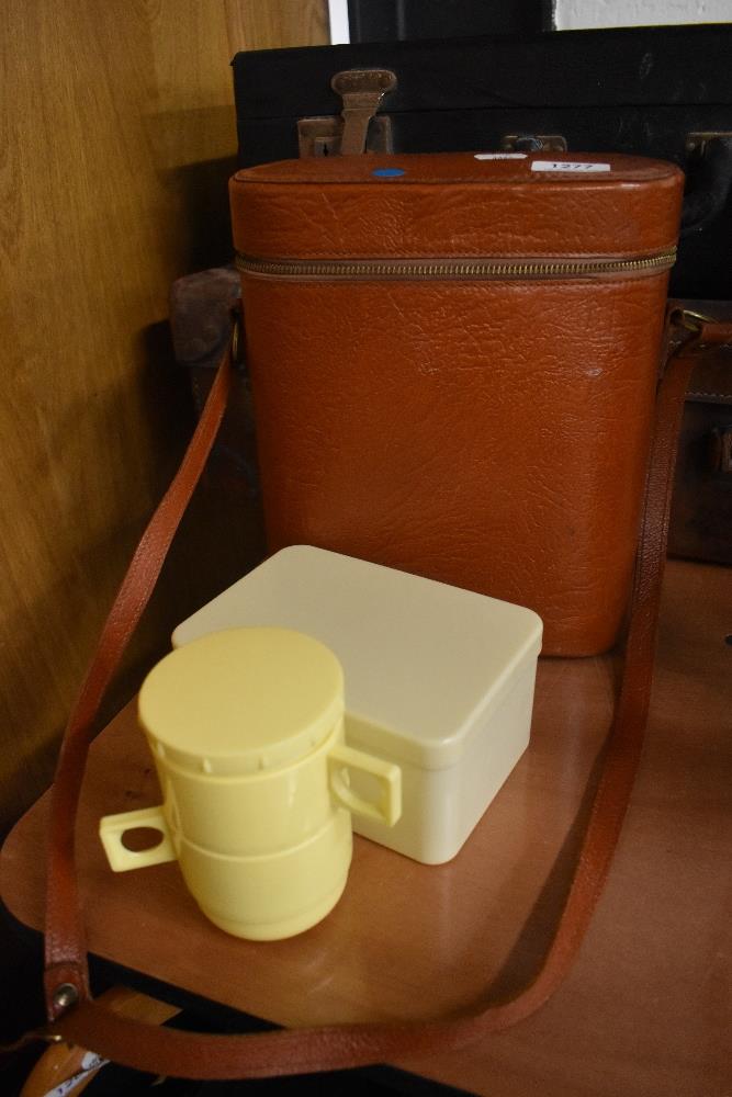 A vintage lunch box including flask, cups and sandwich box.
