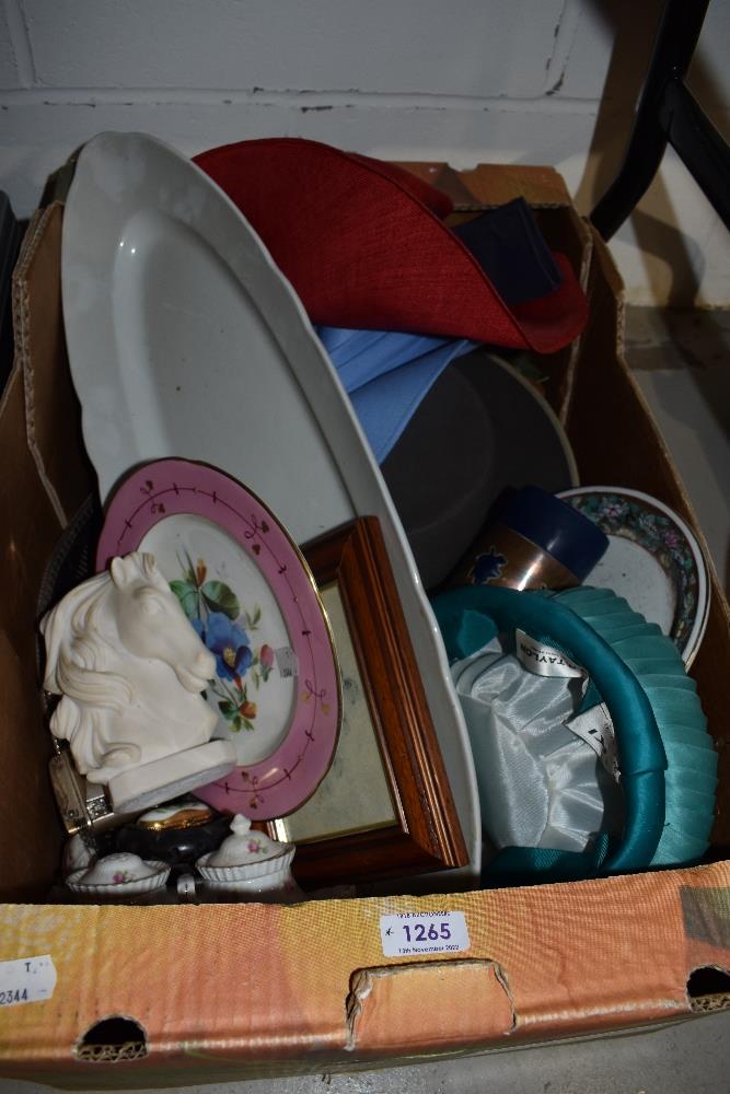 A box containing an interesting selection of items including hats and ceramics.