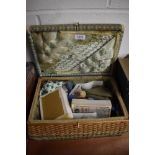 A small fibre woven sewing basket with a selection of haberdashery items