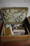 A small fibre woven sewing basket with a selection of haberdashery items