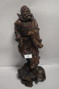 An early 20th century Japanese wood carving of an official figure or samurai, having a damaged