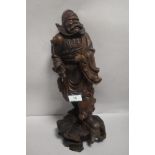 An early 20th century Japanese wood carving of an official figure or samurai, having a damaged