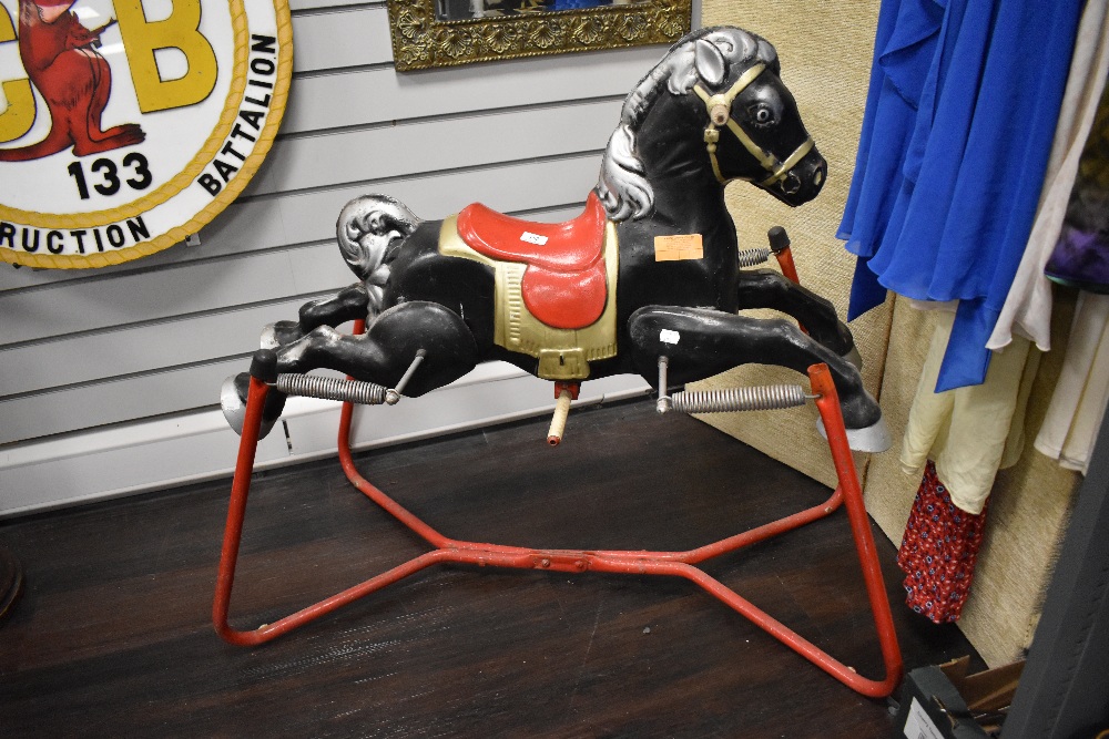A vintage Childs metal rocking horse with sprung action marked made in England, 90cm long.