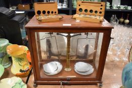 An early 20th century set of cased Chemist or similar balance scales with one complete weight set
