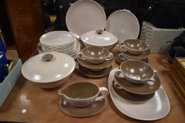 A mid century Poole pottery part dinner service in a cream and brown glaze.