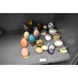 A selection of egg ornaments including stone turned, decorated papier mache, ceramic and cloisonne