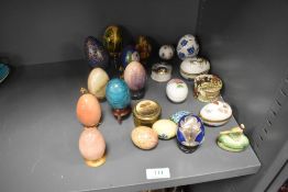 A selection of egg ornaments including stone turned, decorated papier mache, ceramic and cloisonne