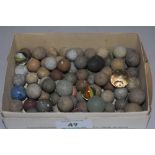A selection of antique games counters balls marbles and shot pieces in glass stone and ceramic