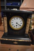 A Victorian French mantel clock having marble column inserts and enamel dial