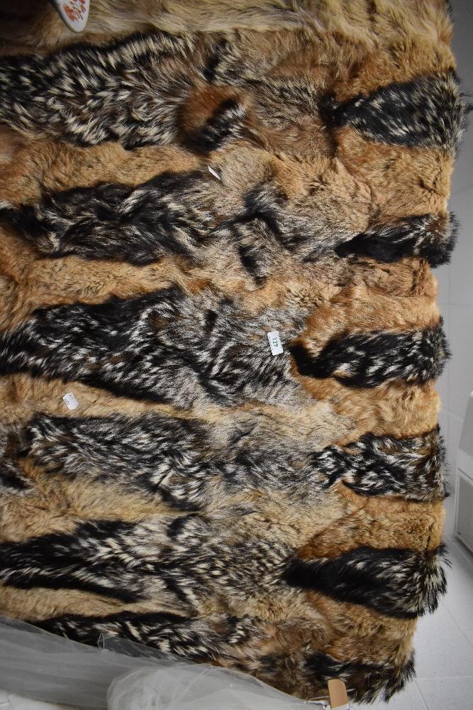 A fox or similar animal hide rug with heads attached, measuring 120cm wide by 150cm long approx