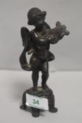 An antique bronze figure study of a cherub playing a lute on four footed plinth. 14cm tall