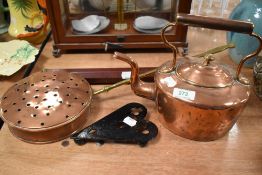 An antique copper stove kettle with a chestnut roaster trivet and telescope