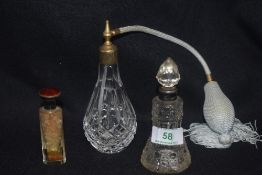 An early 20th century smelling salts bottle having silver and guilloche work top, a cut glass silver