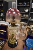 A fine Victorian oil burning lamp having brass base cut glass well and cranberry etched shade
