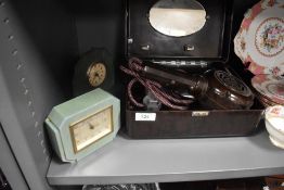 An Art Deco bakelite hair dryer with two green Art Deco mantel clocks,