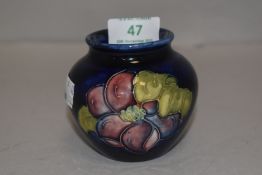 A 20th century Moorcroft small squat vase decorated in a deep blue glaze with Peony design
