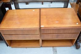 A pair of vintage teak bedside drawer units having two drawers and slide