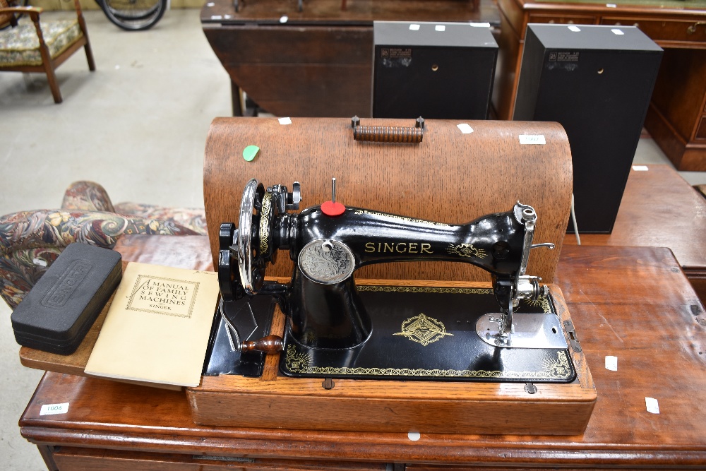A traditional Singer sewing machine having hand crank mechanism and wood case